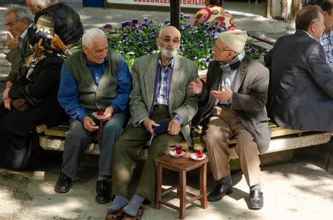 Bursa, Turkey. April 21st 2014 Old Turkish men chatting and drinking tea in a tree shaded square,