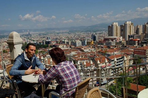 Bursa, Turkey. April 21st 2014 A couple drink tea with the Skyline of the Turkish city of Bursa,