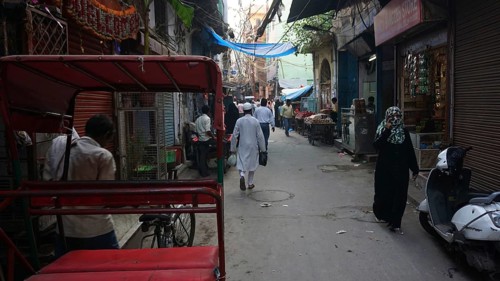 Quiet alley in a Muslim neighborhood of Delhi with isolated people and rickshaws, Delhi, India