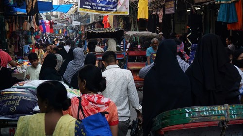Dense crowd in a market scene with lots of rickshaws and hustle and bustle in a Muslim quarter of