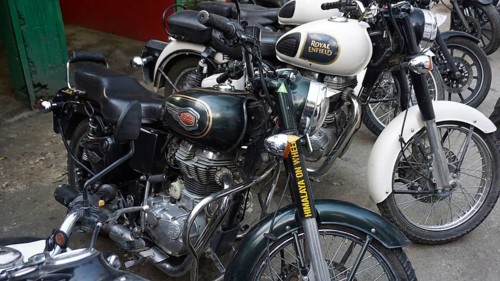 Row of parked Royal Enfield motorcycles in an outdoor area, Manali, Himachal Pradesh, India