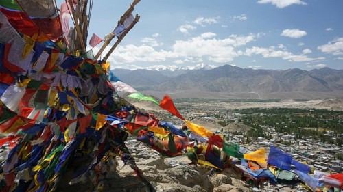 Colourful prayer flags flutter high above a vast mountain landscape, Ladakh, North India,