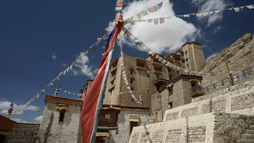 Traditional monastery with colorful prayer flags under blue sky, Ladakh, North India, Himalayas,