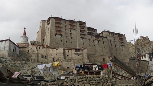 Large fortress complex, Leh Palace with hanging laundry, against cloudy sky, Ladakh, North India,