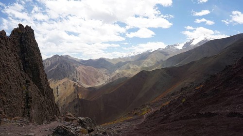 Wide mountain landscape with snowy peaks under cloudy sky, trekking at Stok La Pass in Ladakh,