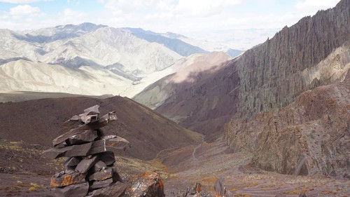 Stone tower as a guide with a view of extensive, rocky mountain landscape, trekking at Stok La Pass