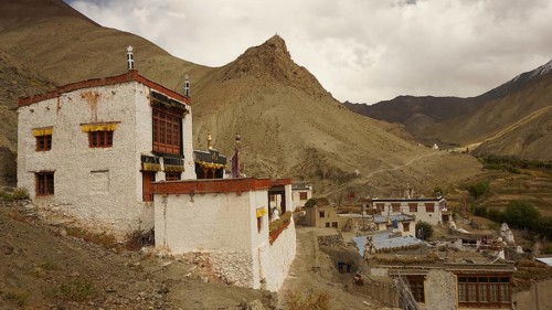 Traditional village on a mountainside under dramatic sky in the Himalayas, trekking in Ladakh,