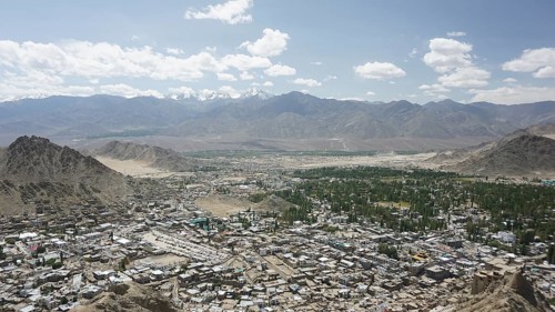 Long-range city view with mountains and sky in the background under white cloudy sky, Ladakh,