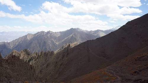 Rocky mountain range under cloudy sky and wide valley, trekking at Stok La Pass in Ladakh,