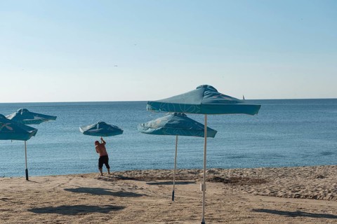 Varna, Bulgaria. September 5th 2020 Setting out sunshade umbrellas on the beach in Varna on the