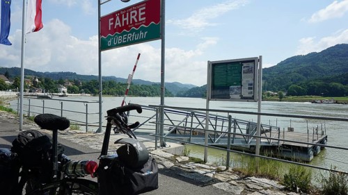 Cycling in front of a ferry with a view of the Danube and mountains, cycling on the Danube cycle