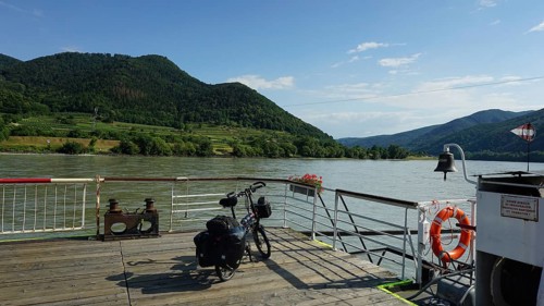 Ferry on the Danube with bicycle and mountains in the background, Danube cycle path, Austria