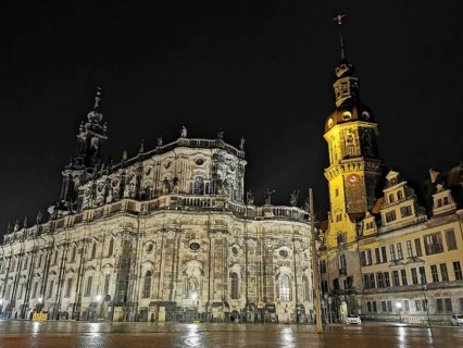 Night view of an illuminated cathedral and a distinctive tower with historic flair in the historic