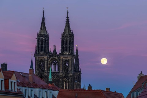 Full moon next to the cathedral towers at blue hour in Meissen, Saxony, Germany
