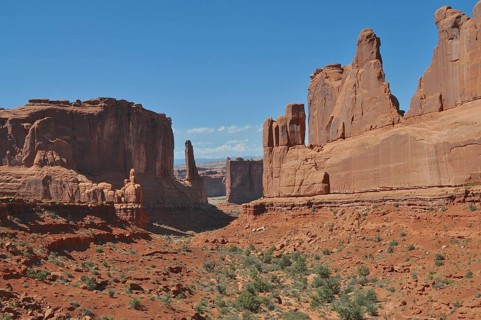 A vast valley with impressive sandstone walls, called Wall Street, and sparse vegetation under a