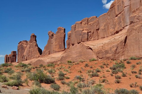 Jagged sandstone formations called Wall Street and sparse vegetation stretch under a clear sky in