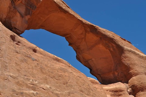 Skyline Arch, a massive sandstone arch in the desert under clear skies, Arches National Park, Utah,