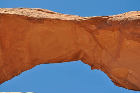 Skyline Arch, a sand-colored rock arch standing out against the blue sky, Arches National Park,