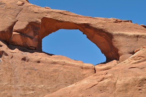 Skyline Arch, a sandstone arch under clear blue sky, Arches National Park, Utah, USA