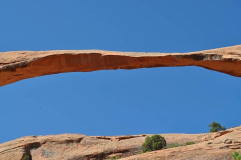 Close-up of a natural stone bridge, called Landscape Arch, against the blue sky, Arches National