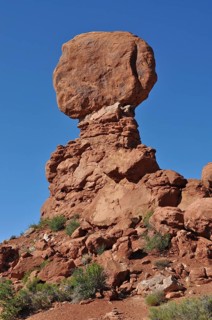 A massive, balanced rock formation in the midst of a barren desert landscape, Arches National Park,