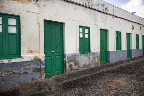 Long, single-storey row of houses in Arrecife, Lanzarote, taken from an oblique perspective. Broken