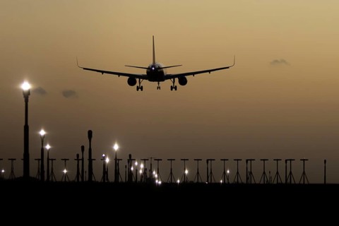 Airbus 320 commercial passenger airliner jet aircraft in flight on approach to land over runway