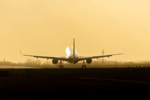 Boeing 777 commercial passenger airliner jet aircraft landing on a runway at sunset at London