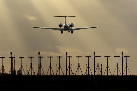 Executive business jet aircraft in flight on approach to land at sunset at London Stansted airport,