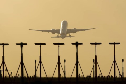 Commercial passenger airliner jet aircraft taking off in flight at sunset at London Stansted