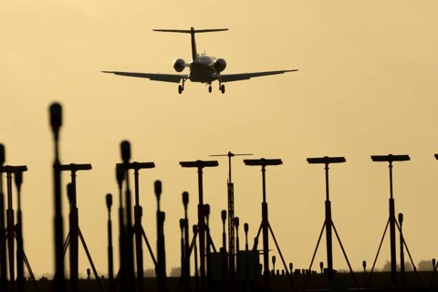 Cessna Citation small executive business jet aircraft in flight on approach to land over runway