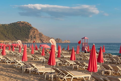 Alanya, Turkey. July 9th 2024 Sunbeds and pink sunshades on Cleopatra Beach in the Turkish holiday