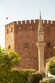 Alanya, Turkey. April 7th 2021 Mineret of Haci Kadiroglu Mosque in front of the famous Red Tower in