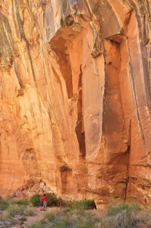 Impressive rock cliff with people below, showing the massive size and natural beauty, Capitol Reef