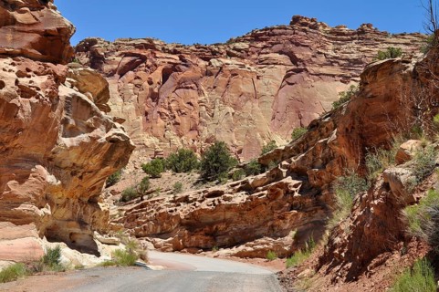 Narrow road through a canyon with impressive red cliffs and clear skies, Capitol Reef National