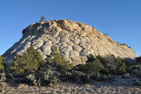 Spherical rock formation with sparse vegetation and clear sky, Capitol Reef National Park, Utha,