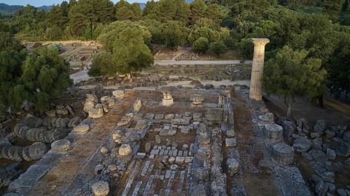 Temple of Zeus in morning light, remains of ancient structures in a wooded region with a prominent