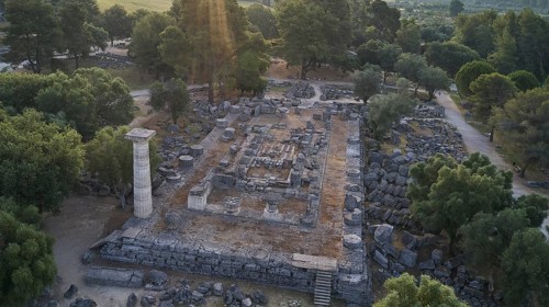 Temple of Zeus in backlight, architectural remains in a forest landscape with a visible stone