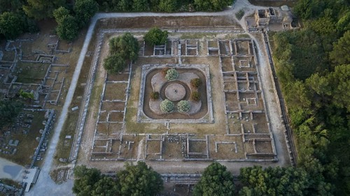 Soft morning light, Leonidaion, square ancient ruins with blooming trees in the middle, drone shot,