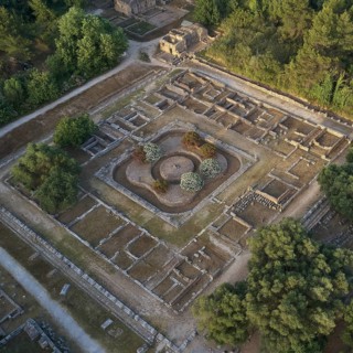 Leonidaion in morning light, symmetrical ancient ruins embedded in a green landscape, photographed