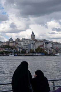 Istanbul, Turkey. September 18th 2025. Muslim women beside the Golden Horn with the Galata Tower