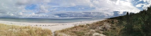 Wide beach landscape with clear sea under cloudy sky, Rügen, Baltic Sea