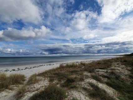 Quiet beach with grassy dunes under a wide, cloudy sky, Rügen, Baltic Sea