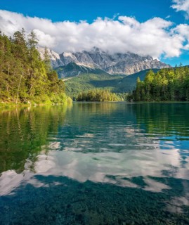 View over Lake Eibsee lake, the Wetterstein Mountains with the Zugspitze in the background, clouds