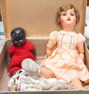 Dolls from 1920s to 1940sin a suitcase, one with articulated limbs and painted features, the other