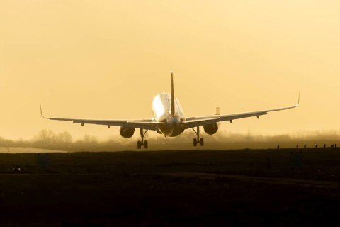 Boeing 777 commercial passenger airliner jet aircraft landing on a runway at sunset at London
