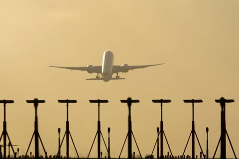 Commercial passenger airliner jet aircraft taking off in flight at sunset at London Stansted