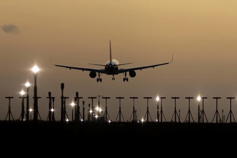 Airbus 320 commercial passenger airliner jet aircraft in flight on approach to land over runway