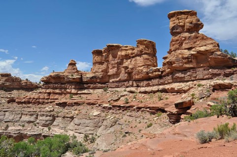 Several towering rock structures rise above a rugged desert landscape, Canyonlands National Park,