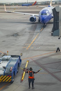 Phoenix, Arizona - A ground crew worker directs a Southwest Airlines jet as it arrives at Sky
